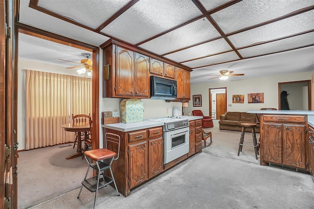 kitchen with white range with electric stovetop, ceiling fan, a kitchen bar, and a textured ceiling