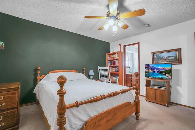 carpeted bedroom with ceiling fan, ensuite bathroom, and a textured ceiling