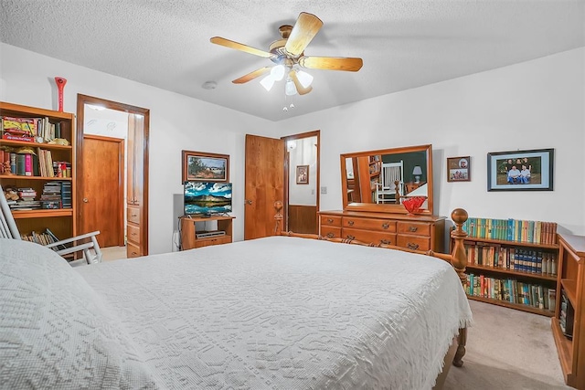 carpeted bedroom featuring ceiling fan and a textured ceiling