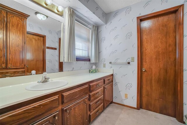 128 W Quail Dr, Cordell, OK 73632 - bathroom with wallpapered walls, vanity, and a textured ceiling