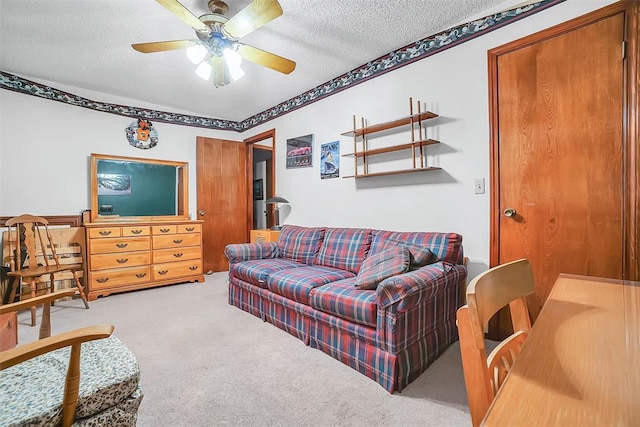 carpeted living room featuring a textured ceiling and ceiling fan