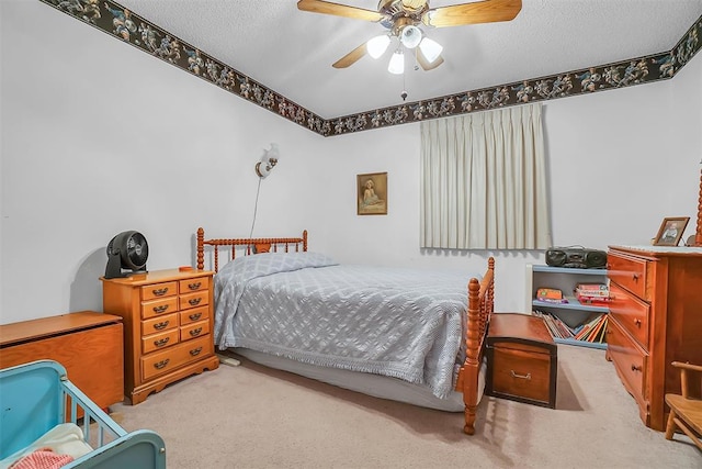 carpeted bedroom with ceiling fan and a textured ceiling