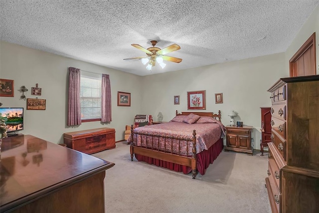 carpeted bedroom with ceiling fan and a textured ceiling