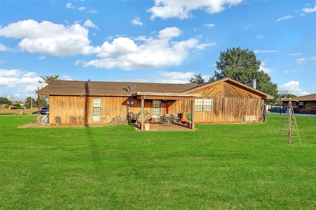 back of property with a lawn and a patio area