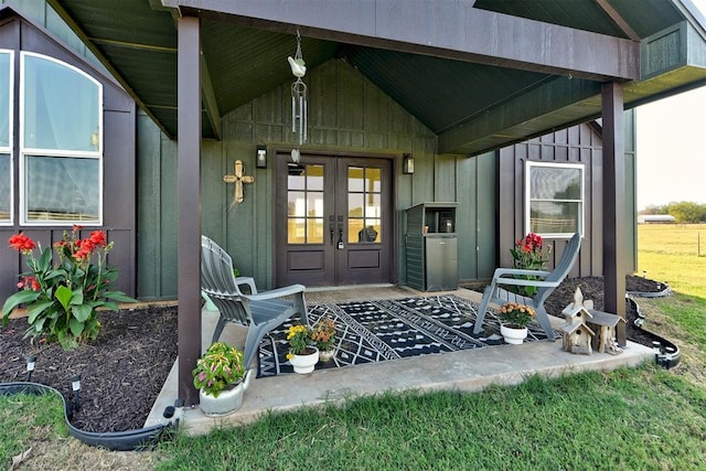 view of exterior entry featuring french doors and a yard