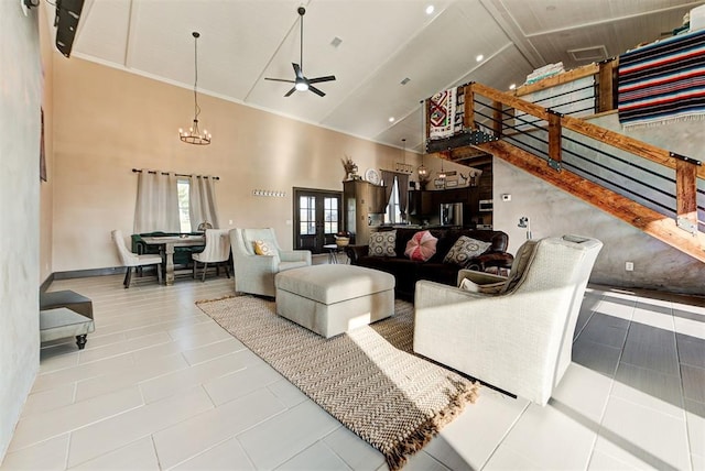 living room with tile patterned floors, ceiling fan with notable chandelier, and high vaulted ceiling