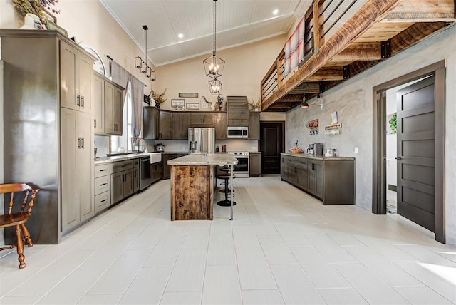 kitchen featuring a breakfast bar, appliances with stainless steel finishes, decorative light fixtures, a kitchen island, and wood ceiling