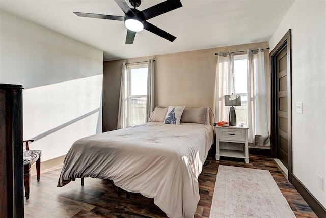 bedroom featuring multiple windows, ceiling fan, and dark wood-type flooring