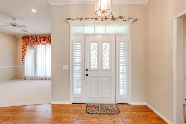 entrance foyer featuring light hardwood / wood-style flooring, ceiling fan, and ornamental molding