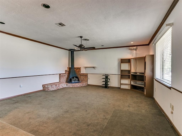 unfurnished living room with a wood stove, a textured ceiling, and dark colored carpet