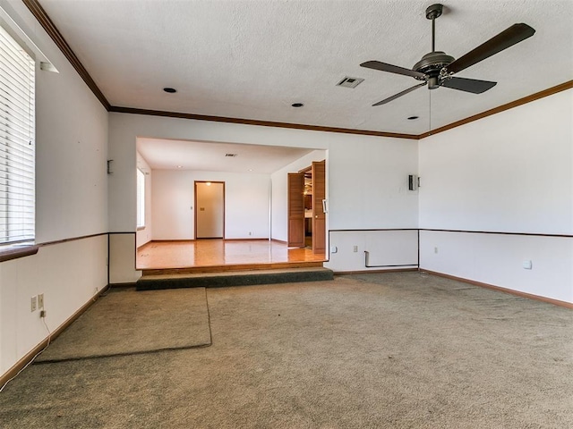 carpeted empty room featuring a textured ceiling, ceiling fan, and ornamental molding