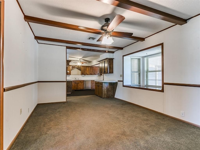 interior space with ceiling fan, beamed ceiling, dark carpet, and stainless steel dishwasher