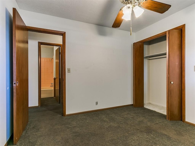 unfurnished bedroom featuring dark colored carpet, a closet, and ceiling fan