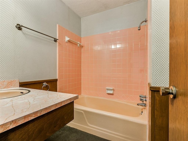 bathroom featuring tiled shower / bath combo, a textured ceiling, and vanity