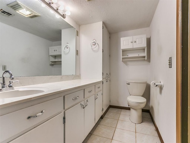 bathroom featuring tile patterned floors, vanity, a textured ceiling, and toilet