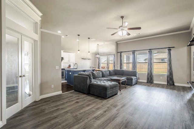 living room featuring dark hardwood / wood-style floors, ornamental molding, and french doors