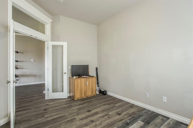 unfurnished living room featuring french doors and dark wood-type flooring