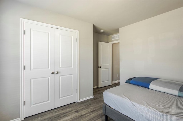 bedroom with a closet and dark wood-type flooring