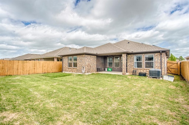 rear view of house featuring central AC unit, a patio area, and a yard