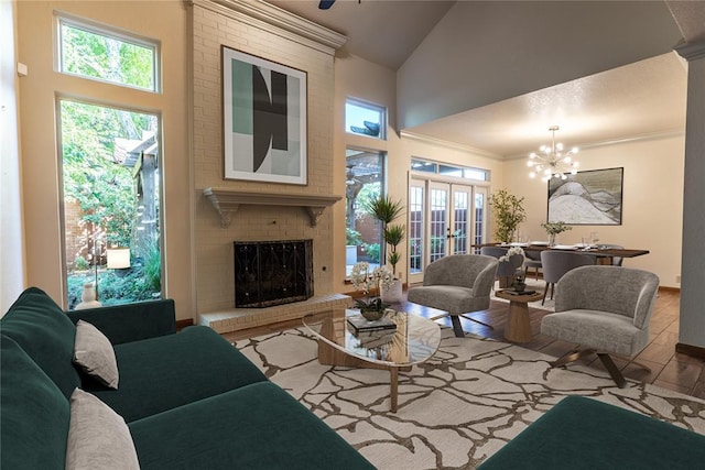 living room with french doors, light wood-type flooring, a brick fireplace, high vaulted ceiling, and a notable chandelier