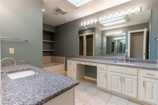 bathroom featuring a skylight, a washtub, tile patterned flooring, built in features, and vanity