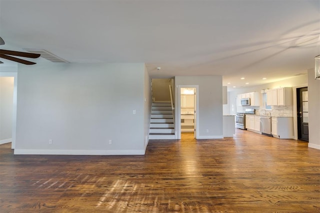 unfurnished living room with ceiling fan, dark hardwood / wood-style flooring, and sink