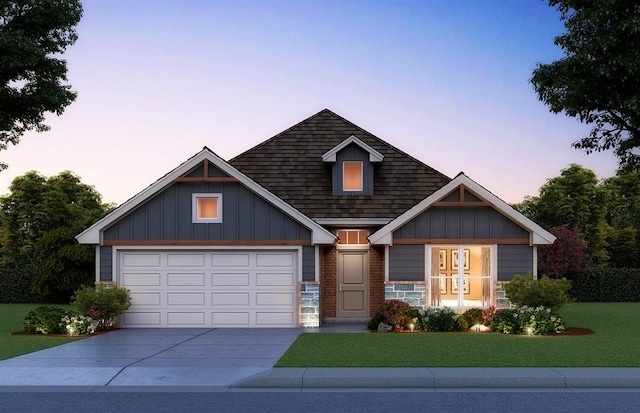 view of front of home with a garage and a lawn