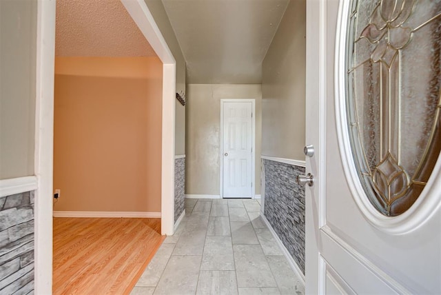 entryway featuring a textured ceiling and light hardwood / wood-style flooring