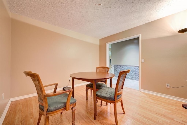 dining area featuring a textured ceiling and light hardwood / wood-style flooring