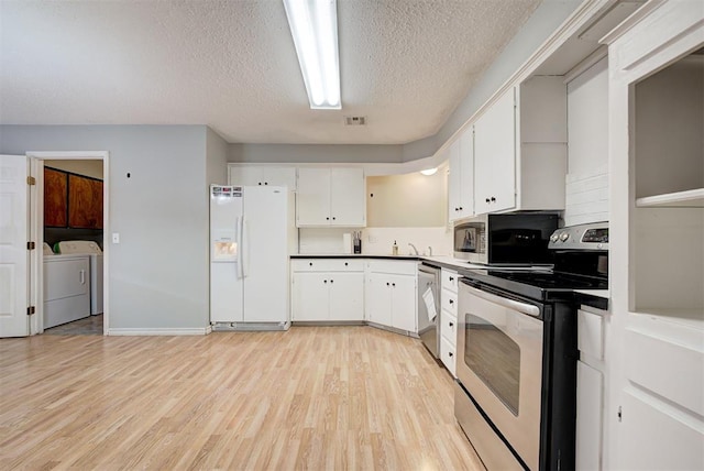 kitchen with white cabinets, light hardwood / wood-style flooring, washing machine and dryer, a textured ceiling, and appliances with stainless steel finishes