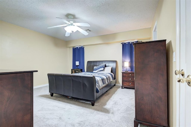 bedroom featuring a textured ceiling, ceiling fan, and light carpet