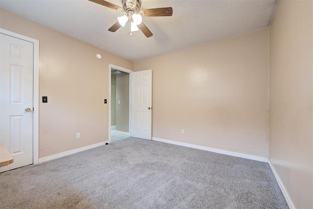 empty room with a textured ceiling, ceiling fan, and light carpet