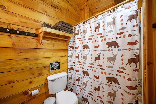 bathroom featuring wood walls and toilet