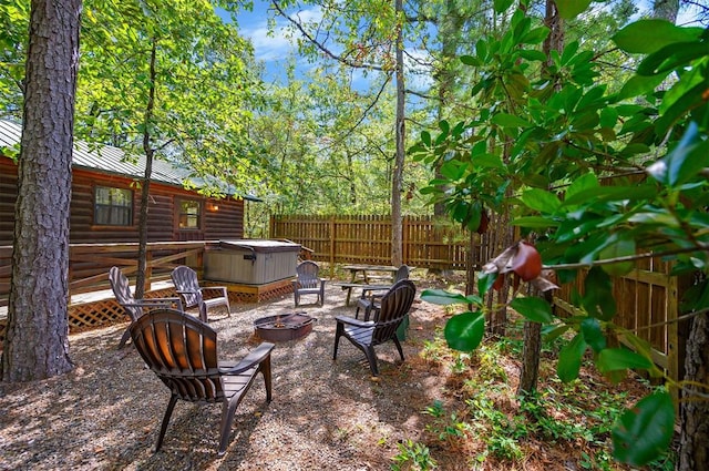 view of patio / terrace with a hot tub and an outdoor fire pit