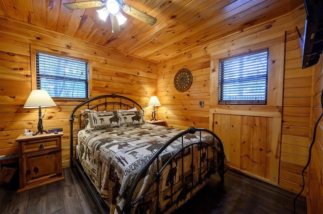 bedroom featuring ceiling fan, dark hardwood / wood-style flooring, wood ceiling, and wooden walls