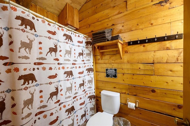 bathroom with toilet and wooden walls