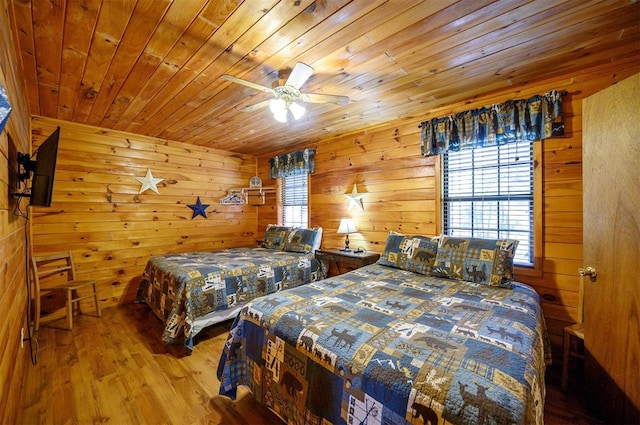 bedroom featuring hardwood / wood-style floors, wooden ceiling, ceiling fan, and wooden walls