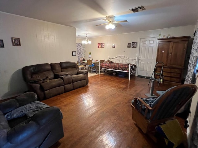 living room with hardwood / wood-style floors and ceiling fan with notable chandelier