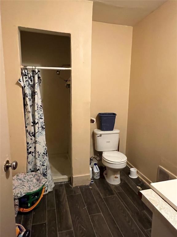 bathroom with a shower with shower curtain, vanity, hardwood / wood-style flooring, and toilet