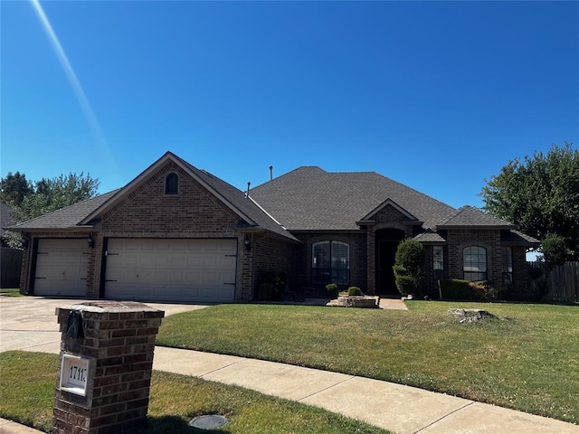 view of front of house featuring a garage and a front lawn