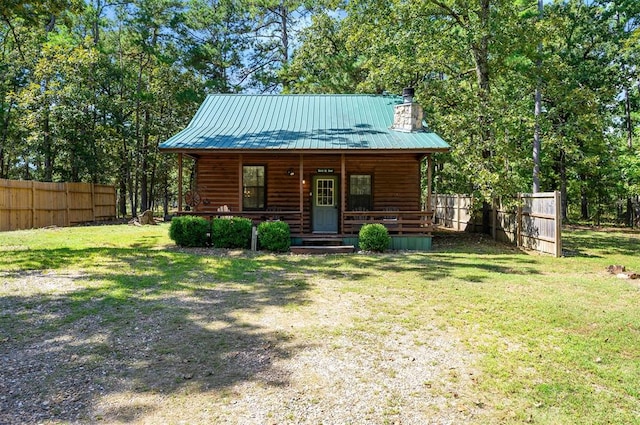 log cabin featuring covered porch and a front lawn