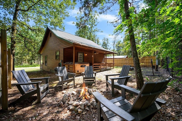 exterior space with a hot tub and an outdoor fire pit