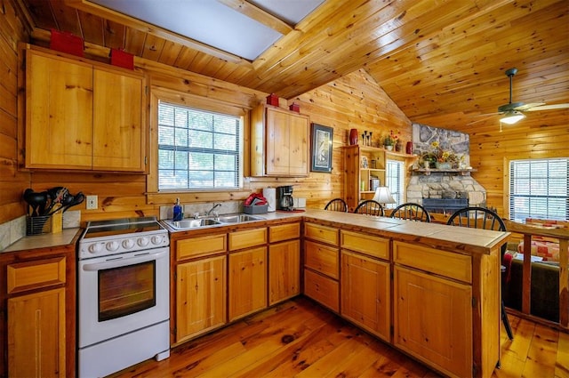 kitchen with sink, white range with electric stovetop, kitchen peninsula, vaulted ceiling, and hardwood / wood-style flooring