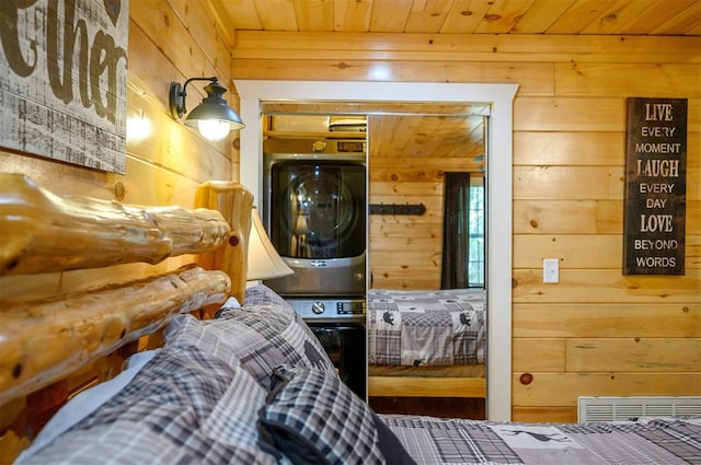 laundry room with wood ceiling, stacked washer / dryer, and wooden walls