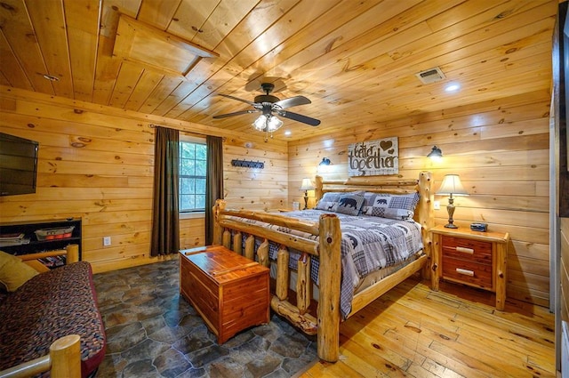 bedroom featuring wooden walls, hardwood / wood-style floors, ceiling fan, and wood ceiling