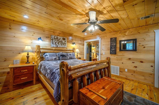 bedroom with ceiling fan, wood walls, wood ceiling, and light hardwood / wood-style flooring