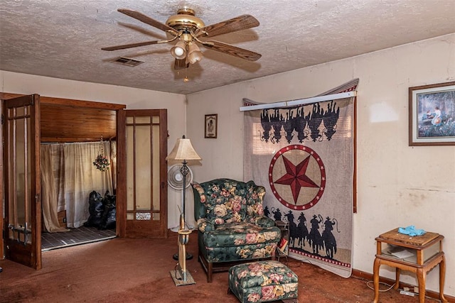 living area featuring carpet, french doors, a textured ceiling, and ceiling fan