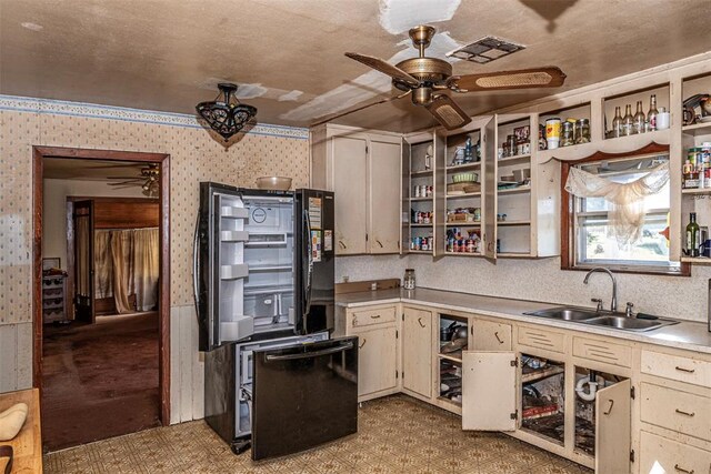 kitchen with ceiling fan, black fridge, sink, and cream cabinets