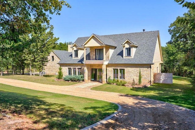 craftsman-style home with a balcony and a front lawn