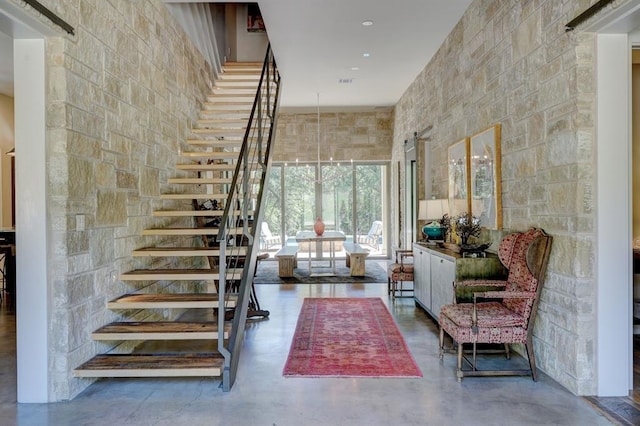 stairs with concrete flooring and a high ceiling